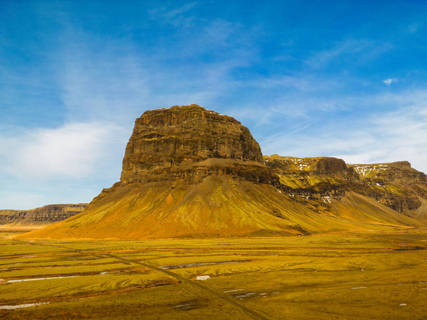 Εναέρια άποψη της μαζικής οροσειράς στην Ισλανδία, τεράστιες πλαγιές με καφέ βράχια σε σκανδιναβικό ορεινό τοπίο. Όμορφη icelandic τοπίο με μεγάλο λόφο γύρω από παγωμένο βοσκοτόπια. - Φωτογραφία, εικόνα