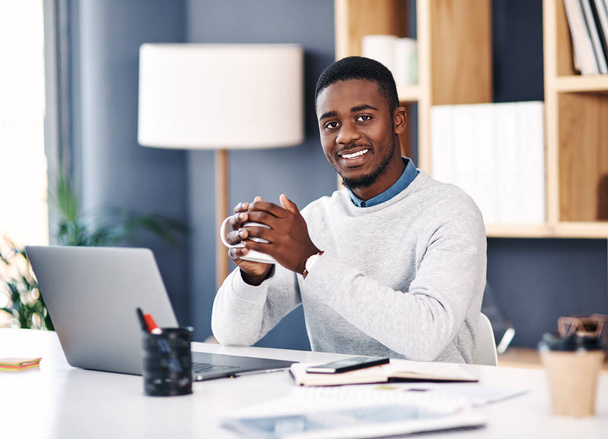 Portrait, employee and black man at desk, coffee and laptop with professional and career ambition. African person, face or entrepreneur with morning tea or pc with agent and business owner with smile. - Photo, Image
