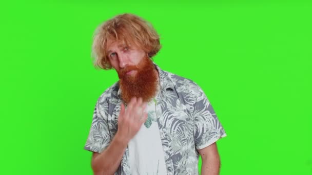 Smiling playful happy young caucasian man blinking eye, looking at camera with smile, winking, flirting, expressing optimism, good news. Charming redhead guy isolated on green chroma key background - Footage, Video