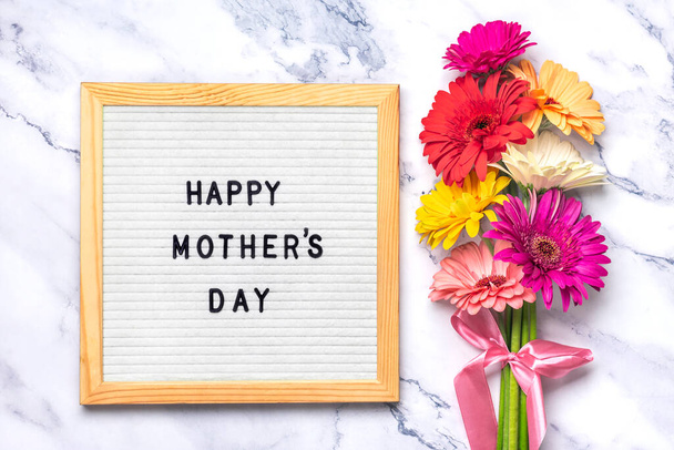 Felt tábla szöveggel Boldog Anyák napját, színes gerberák csokor szürke háttér üdvözlő üdvözlő kártya Lapos feküdt Felülnézet. - Fotó, kép