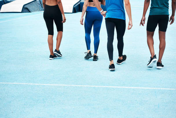 People, team and legs on race track or stadium for training, outdoor or workout on stands for wellness. Group, diversity and sportswear on break in exercise for tournament, competition or contest. - Photo, image