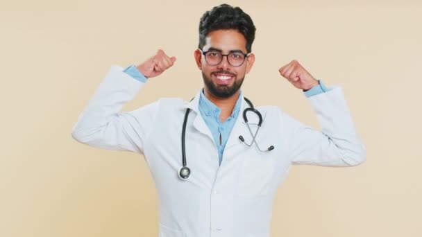 Я лучше всех. Счастливый удовлетворенный эгоистичный индийский молодой врач-кардиолог гордится триумфом победы, хвастаясь собственным успехом, выигрывает достижения. Аптекарь арабского происхождения, изолированный на бежевом фоне - Кадры, видео