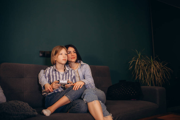 μητέρα και κόρη βλέποντας τηλεόραση στον καναπέ - Φωτογραφία, εικόνα