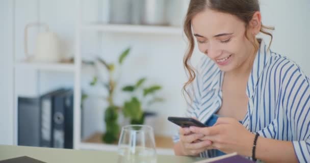 Pozitív nő boldogan SMS-ezés és vásárlás online okostelefonon - Felvétel, videó