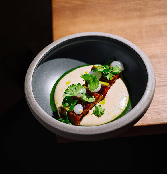 High-end cuisine in a black bowl, artistically plated with a modern touch - Photo, Image