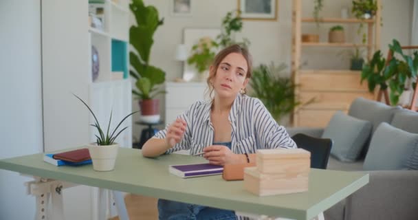 Zittend aan haar bureau, een vrouw lijkt verdrietig en ontmoedigd als ze worstelt om het materiaal te begrijpen, geconfronteerd met uitdagingen in haar leerreis - Video