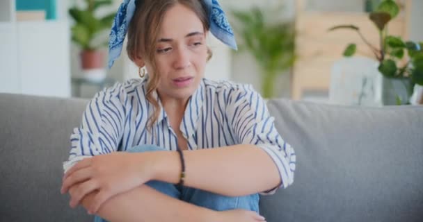Num momento de profunda tristeza, uma mulher senta-se no sofá, com os olhos cheios de lágrimas por derramar, a sua expressão carregada de tristeza e agitação emocional - Filmagem, Vídeo
