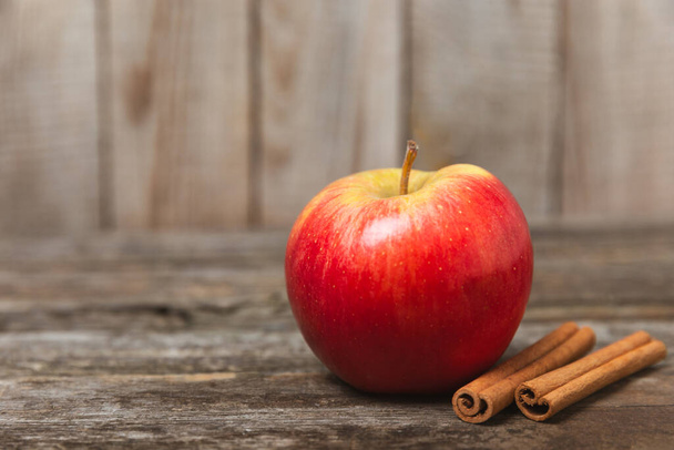 テクスチャされた木の背景にシナモンが付いているリンゴ. シナモンスティックと星アニスと香りの赤いスパイスアップル. Appleはスパイシーなスパイスをスライスした. テキストの場所。 スペースをコピーする。 収穫する. フルーツ。 ビーガン ビーガン. - 写真・画像
