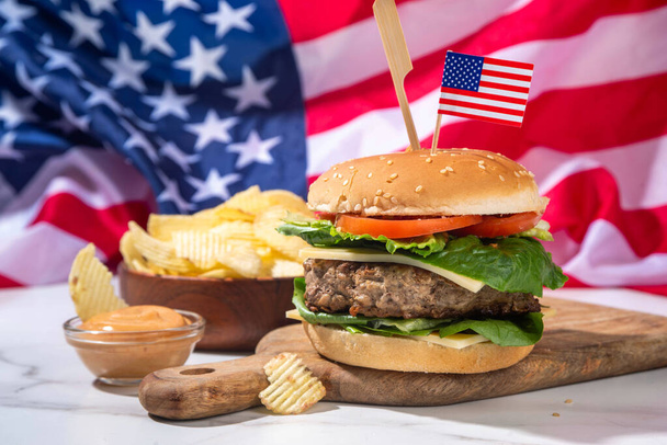 Gustosi cheeseburger, patatine e salsa con bandiera patriottica americana. 4 luglio, Giorno dell'indipendenza pic-nic party food, spazio copia hamburger bbq a tema USA - Foto, immagini