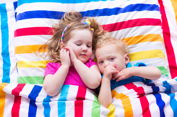 Enfants dormant sous une couverture colorée
 - Photo, image