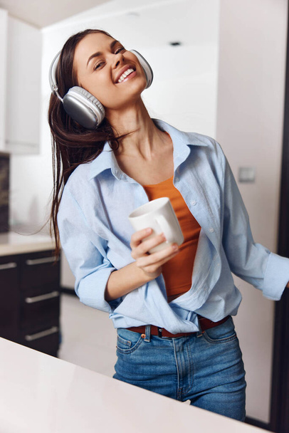 Junge Frau genießt Musik und Kaffee in Küche - Foto, Bild