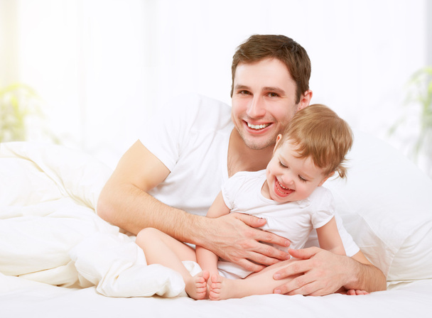 Mutlu aile baba ve bebek kız yatakta oynarken - Fotoğraf, Görsel
