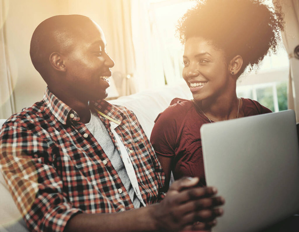 Home, smile and black couple with laptop, sunshine and connection with internet, relaxing and lens flare. Apartment, streaming service and man with woman, computer and happiness with marriage or love. - Photo, Image
