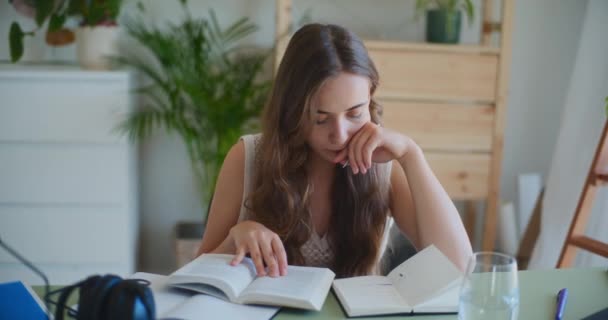 Γυναίκα βαθιά συγκεντρωμένη, διαβάζοντας και μελετώντας στο γραφείο της - Πλάνα, βίντεο