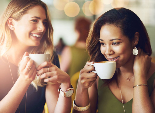 Women, friends and drinking in coffee shop or laughing for reunion connection or restaurant, relax or caffeine. Female people, cup and chatting together in cafe with funny joke, humor or espresso. - Photo, Image