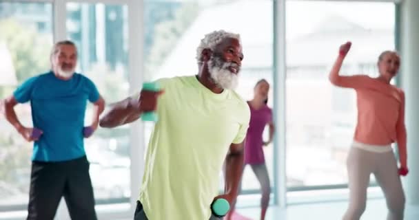 Γυμναστική, βάρη και ηλικιωμένοι στο γυμναστήριο για την υγεία, την ευεξία και το βραχίονα προπόνηση τάξη. Αθλητισμός, ποικιλομορφία και ανώτεροι φίλοι που τεντώνονται για μυϊκή άσκηση ή προπόνηση με αλτήρες στο στούντιο - Πλάνα, βίντεο