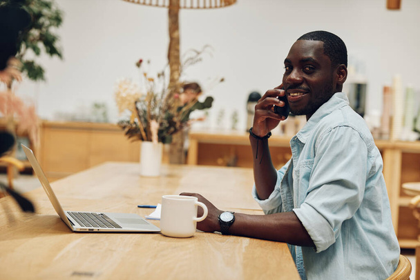 Man table boldog munka modern kapcsolat professzionális laptop felnőtt technológia portré személy számítógép ül üzletember dolgozik üzlet afrikai fiatal férfi irodai kommunikáció cyberspace életmód - Fotó, kép