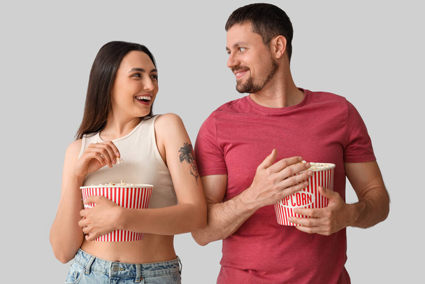 Felice giovane coppia mangiare popcorn su sfondo chiaro - Foto, immagini