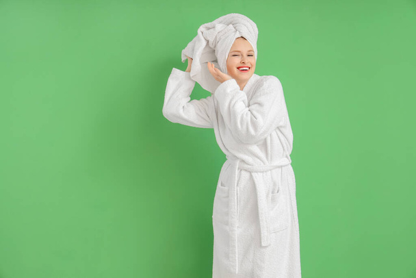Jovem mulher em roupão de banho após chuveiro no fundo verde - Foto, Imagem