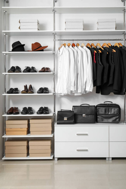 Rack with clothes and shoes in modern man's wardrobe - Photo, Image