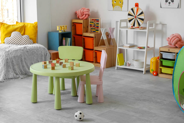 テーブルとおもちゃ付きのモダンな子供部屋のインテリア - 写真・画像