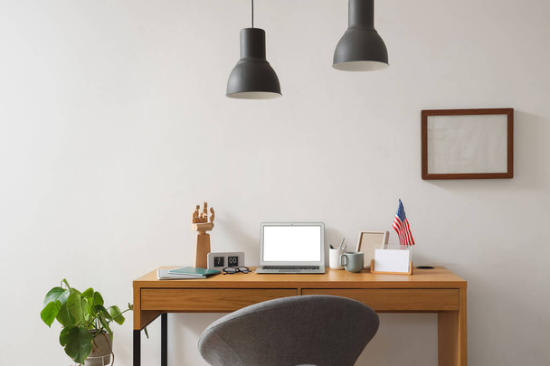 Interior of stylish office with workplace, laptop and USA flag near white wall - Photo, Image