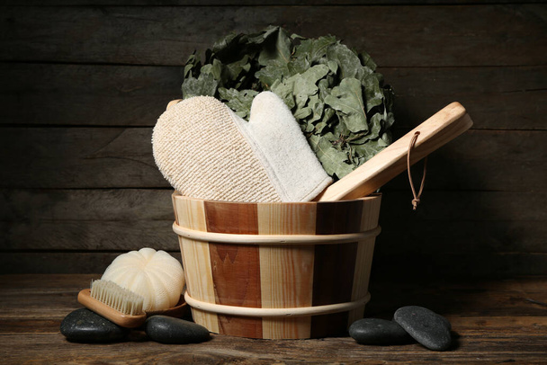 Bucket with different supplies for sauna on wooden background - Photo, Image