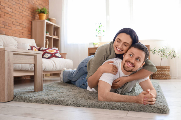 Junges Paar liegt zu Hause auf grünem Teppich - Foto, Bild