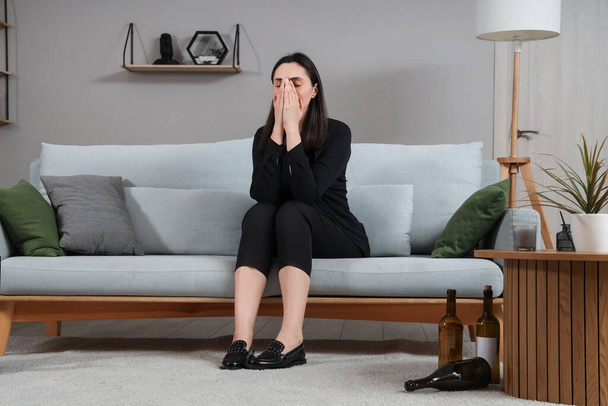 Depressive junge Frau sitzt nach Beerdigung zu Hause auf Sofa - Foto, Bild