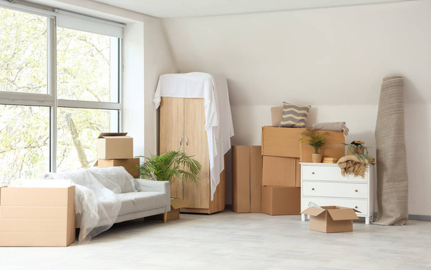 Cajas de cartón con muebles en la habitación en el día en movimiento - Foto, Imagen