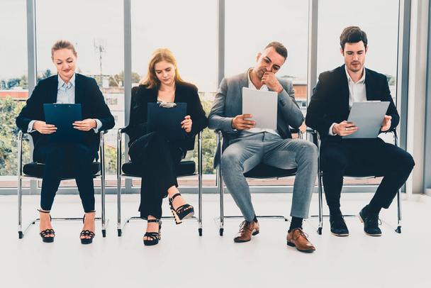 Bizneswoman i biznesmen trzymający CV folderu podczas oczekiwania na krzesła w biurze na rozmowę kwalifikacyjną. Koncepcja biznesu i zasobów ludzkich. uds - Zdjęcie, obraz