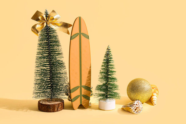 Композиция с рождественскими украшениями, мини-серфинг и раковины на цветном фоне - Фото, изображение