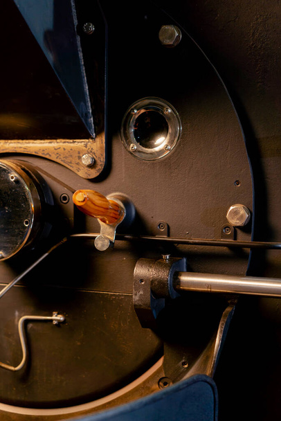 close-up in een koffiebranderij zie je hoe de koffie door de patrijspoort draait - Foto, afbeelding