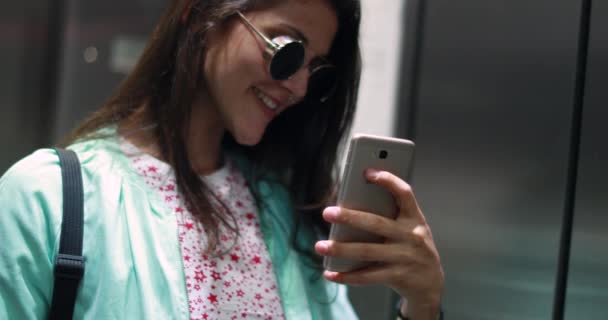 Nuori nainen ottaa selfie valokuva edessä hissi peili - Materiaali, video