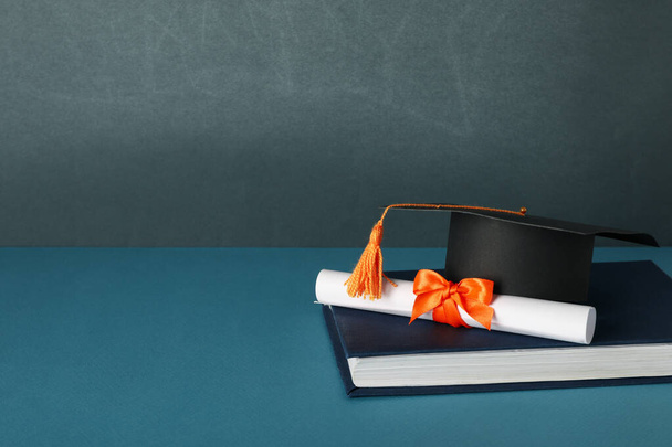 Graduate hoed en boeken, op een blauwe achtergrond. - Foto, afbeelding
