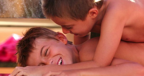 Zabawny moment razem między braćmi jedno dziecko leżące na rodzeństwie kompresujące ciało z ciężarem - Zdjęcie, obraz
