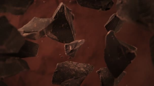 Super Zeitlupe Aufnahme von Schokoladenstücken gefolgt von Kamera fallen in Kakaopulver bei 1000fps. Gefilmt mit High-Speed-Kinokamera, 4K. - Filmmaterial, Video