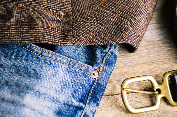 Dettaglio di una cintura in pelle slacciata su un paio di blue jeans sbiaditi
 - Foto, immagini