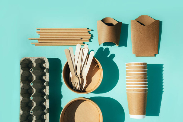 青い背景に紙道具,プレート,木製のカトラリー. エコフレンドリーなパターン,ゼロ廃棄物の概念. トップビュー - 写真・画像