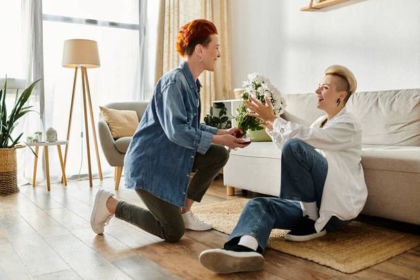 Un homme tend tendrement des fleurs à une femme dans un cadre confortable de salon, montrant un simple acte d'affection. - Photo, image
