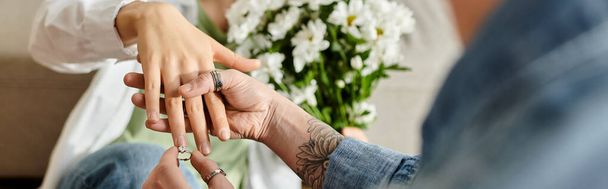 donna mette delicatamente un anello su una mano di partner in un gesto commovente di amore e impegno. - Foto, immagini