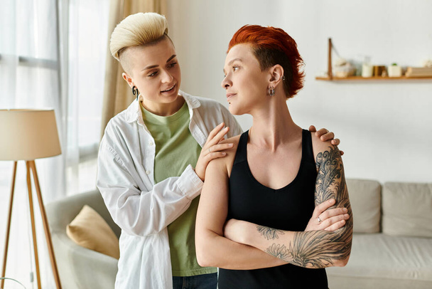 Két rövid hajú nő beszélgetésbe elegyedik egy hangulatos nappaliban. - Fotó, kép