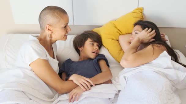 Slow motion video niet-normatieve familie tijd doorbrengen terwijl praten in het bed in de ochtend - Video