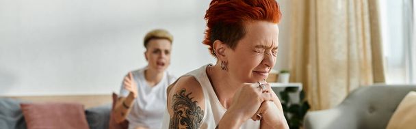 A woman with vibrant red hair is crying on couch, banner - Photo, Image