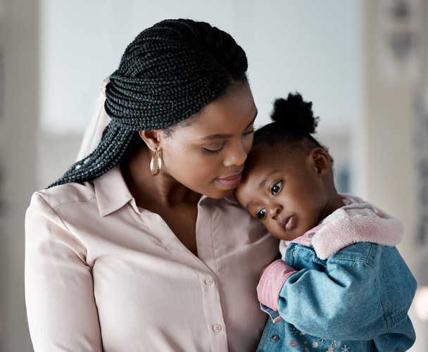 Liefde, comfort of moeder en dochter knuffelen in huis met veiligheid, bescherming en zekerheid in het verbinden met vertrouwen. zwart familie, ondersteuning en moeder omarmen meisje thuis met veiligheid of moederschap dankbaarheid. - Foto, afbeelding
