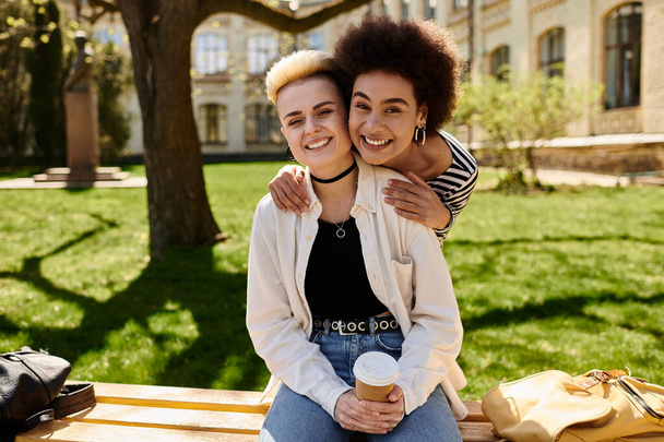 Zwei junge Mädchen in lässiger Kleidung genießen einen friedlichen Moment zusammen auf einer Bank in einer ruhigen Parklandschaft. - Foto, Bild