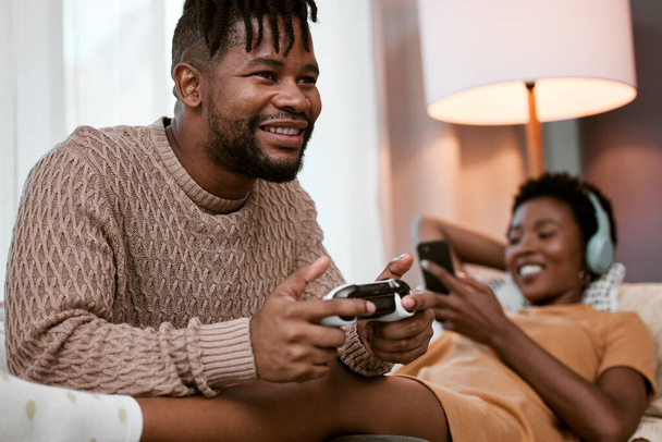 Czarna para, sofa i zadowolony z rozrywki do tworzenia więzi, zabawy i streamingu w domu. Mężczyzna, kobieta i wraz z zrelaksowany na kanapie i telefon do muzyki, gier wideo i zabawy w salonie w Nigerii. - Zdjęcie, obraz