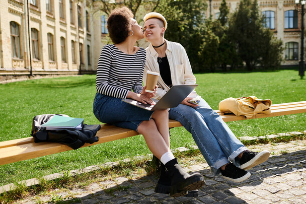 2人の若い女性,1人は長髪,もう1人はポニーテール,公園のベンチに座って平和の瞬間を共有する. - 写真・画像