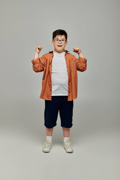 chlapec s Downovým syndromem nosit brýle udeří pózu pro fotoaparát. - Fotografie, Obrázek