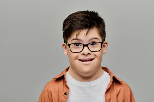Un bambino affascinante con la sindrome di Down che fa giocosamente una faccia buffa. - Foto, immagini